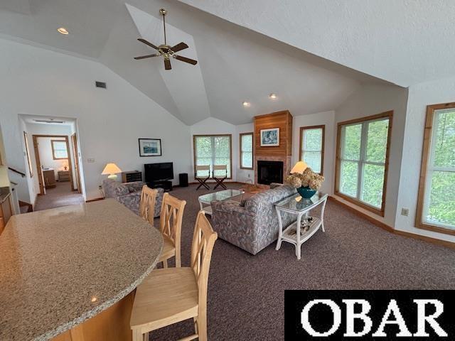 114 Poteskeet Dr Lot 66, Kitty Hawk, NC 27949 - carpeted living area featuring vaulted ceiling, ceiling fan, healthy amount of natural light, baseboards, and a fireplace