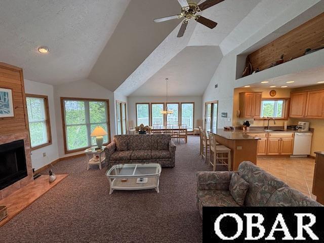 114 Poteskeet Dr Lot 66, Kitty Hawk, NC 27949 - living room featuring plenty of natural light, high vaulted ceiling, a fireplace, a ceiling fan, and light colored carpet