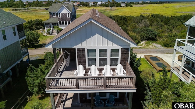 74 Lake Dr, Ocracoke, NC 27960 - back of property featuring board and batten siding, a shingled roof, and a deck