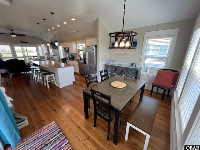 74 Lake Dr, Ocracoke, NC 27960 - dining space with lofted ceiling, wood finished floors, healthy amount of natural light, a ceiling fan, and a chandelier