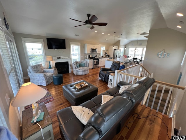 74 Lake Dr, Ocracoke, NC 27960 - living room featuring ceiling fan, vaulted ceiling, plenty of natural light, wood finished floors, and a fireplace