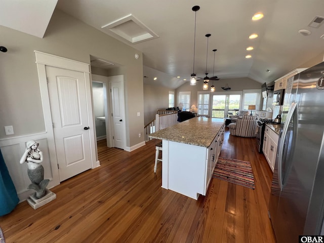 74 Lake Dr, Ocracoke, NC 27960 - kitchen with stainless steel appliances, white cabinets, a breakfast bar area, vaulted ceiling, and a kitchen island