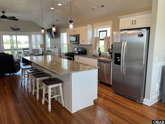 74 Lake Dr, Ocracoke, NC 27960 - kitchen with stainless steel appliances, dark wood-style flooring, a kitchen island, white cabinets, and lofted ceiling