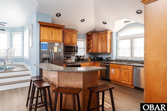 567 Ocean Trl Lot 140, Corolla, NC 27927 - kitchen with appliances with stainless steel finishes, a sink, brown cabinetry, a breakfast bar area, and vaulted ceiling