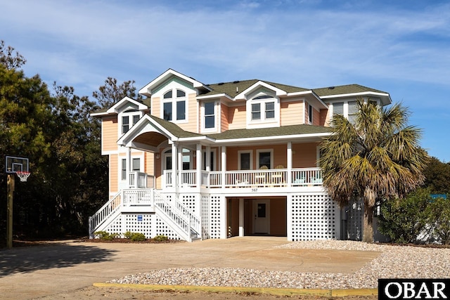 567 Ocean Trl Lot 140, Corolla, NC 27927 - coastal home with covered porch, concrete driveway, a shingled roof, and a carport