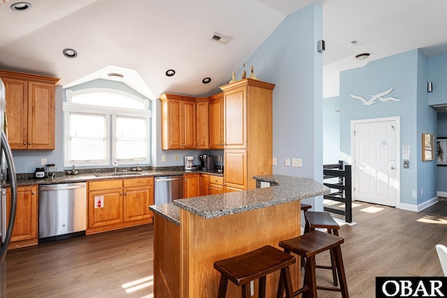 567 Ocean Trl Lot 140, Corolla, NC 27927 - kitchen with stainless steel dishwasher, lofted ceiling, a kitchen bar, a sink, and wood finished floors
