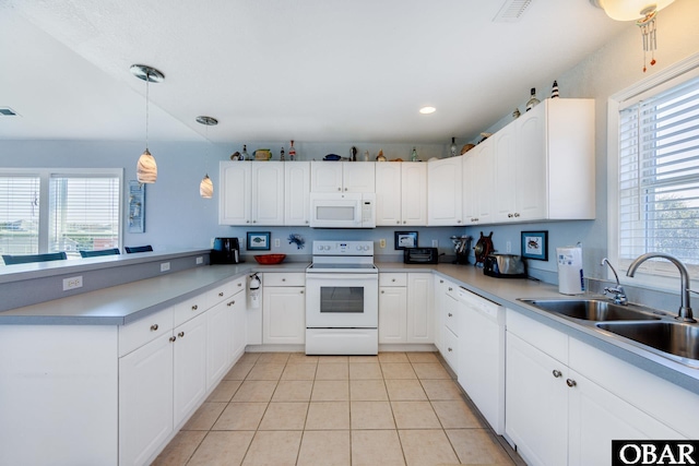 kitchen featuring a peninsula, white appliances, a sink, and white cabinetry