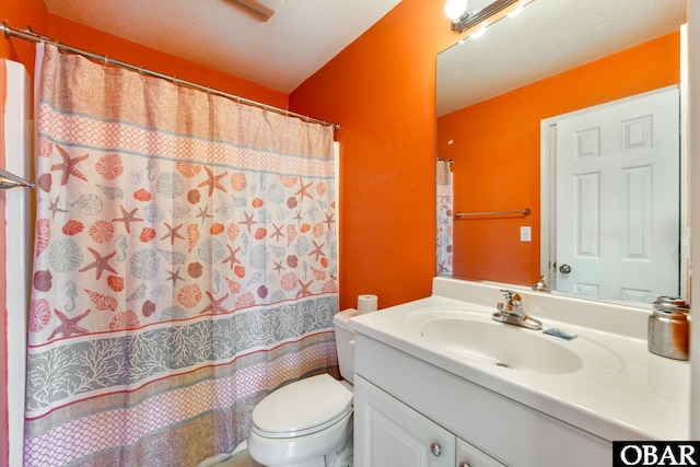 bathroom featuring a textured ceiling, toilet, a shower with shower curtain, and vanity