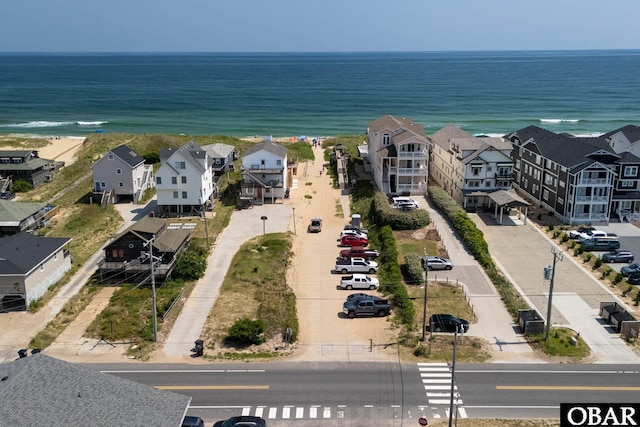 bird's eye view with a water view, a view of the beach, and a residential view