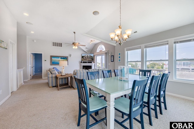 dining space with visible vents, a fireplace, light colored carpet, and a healthy amount of sunlight