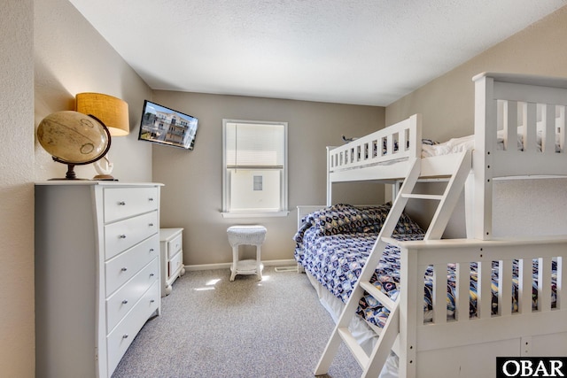 bedroom with carpet flooring, a textured ceiling, and baseboards