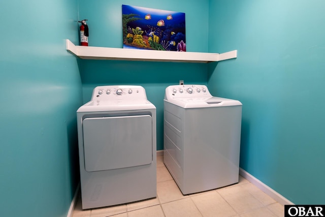 clothes washing area featuring laundry area, baseboards, washer and dryer, and tile patterned floors