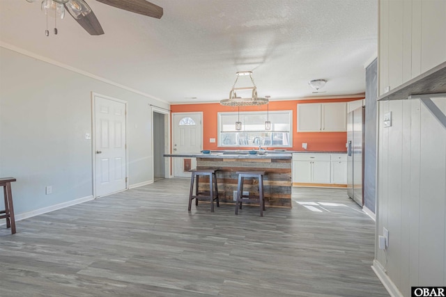 kitchen featuring a center island, light wood-style flooring, a textured ceiling, and stainless steel refrigerator with ice dispenser