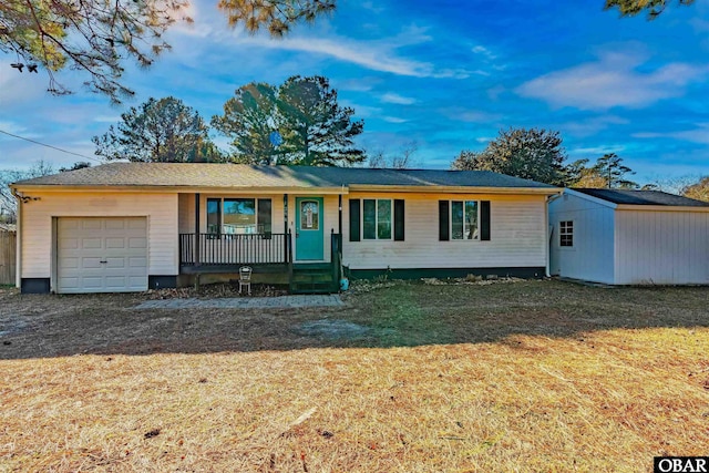 single story home with a garage, a porch, a front lawn, and a shed