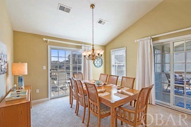 dining room with light carpet, lofted ceiling, visible vents, and an inviting chandelier