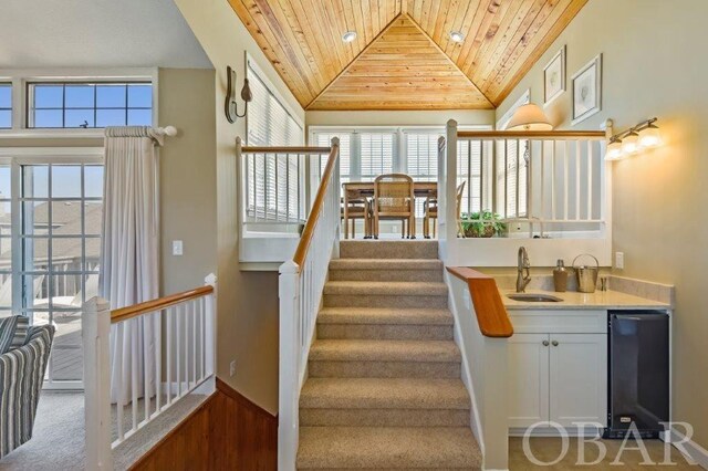 stairway featuring wooden ceiling and vaulted ceiling