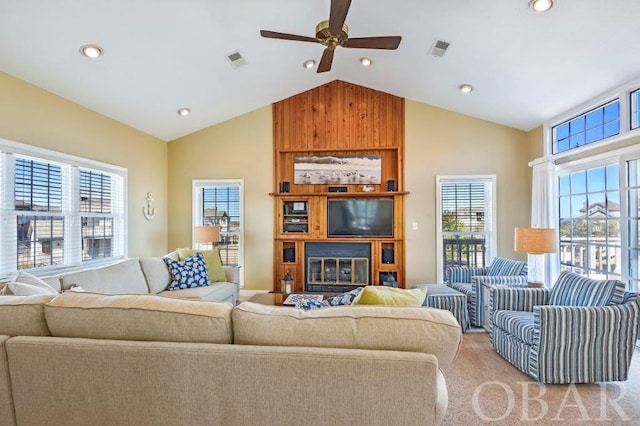 living area featuring ceiling fan, high vaulted ceiling, visible vents, and light colored carpet