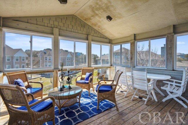 sunroom with lofted ceiling and a residential view