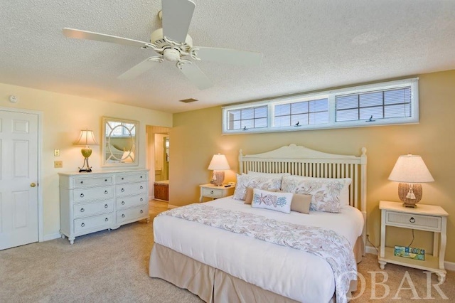 bedroom featuring light carpet, visible vents, connected bathroom, ceiling fan, and a textured ceiling