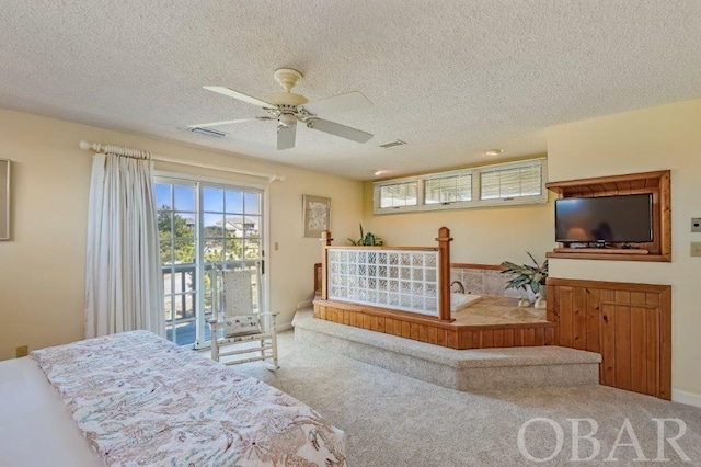 bedroom with carpet, access to outside, visible vents, and a textured ceiling