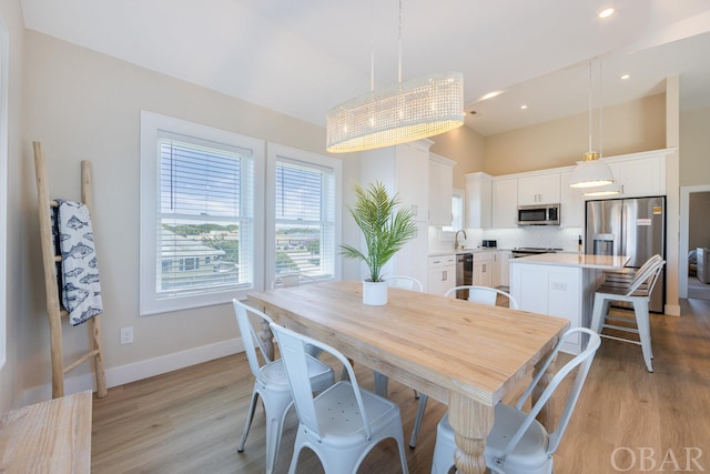 dining room with baseboards, recessed lighting, and light wood-style floors