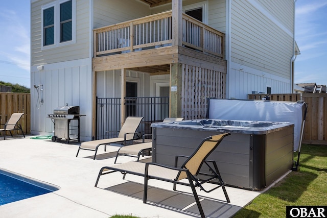 view of patio featuring a balcony, a hot tub, fence, and area for grilling