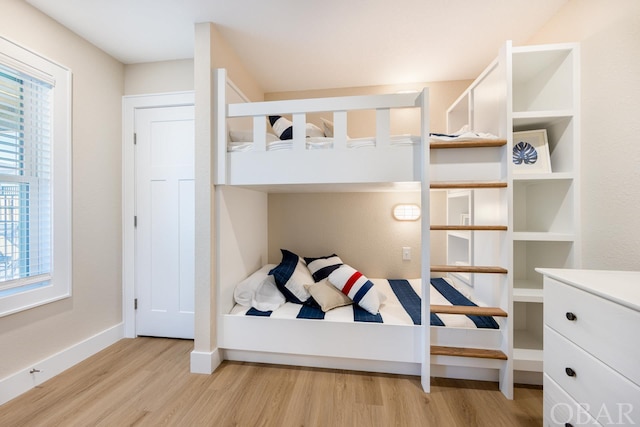 bedroom with light wood-type flooring and baseboards