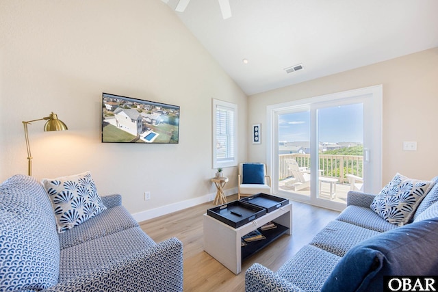 living room with baseboards, high vaulted ceiling, visible vents, and light wood-style floors