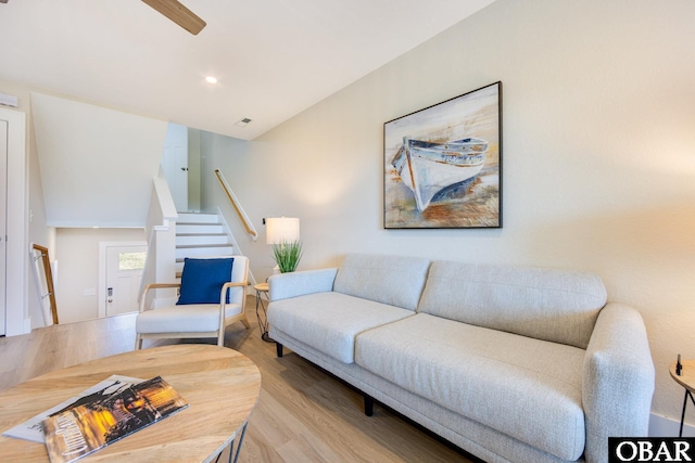 living room with stairway, recessed lighting, and light wood-style floors