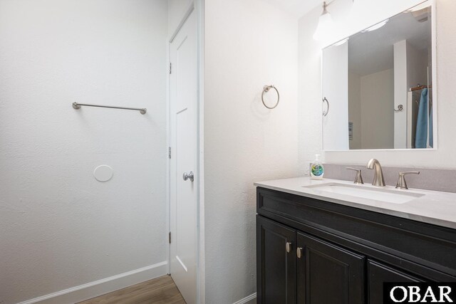 bathroom featuring vanity, baseboards, and wood finished floors