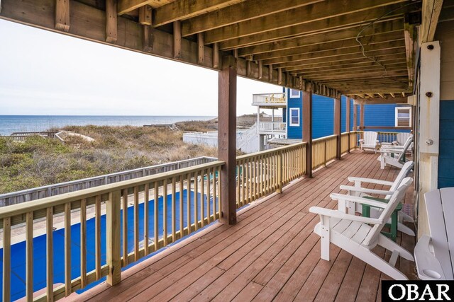 deck with a pool and a water view