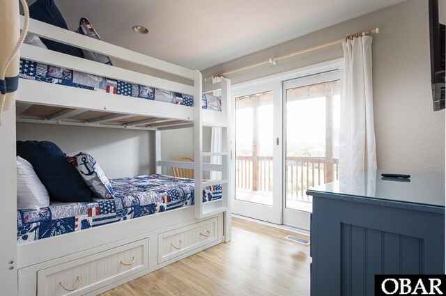 bedroom featuring light wood-style floors, visible vents, and access to exterior