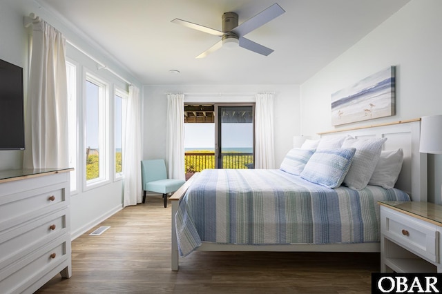 bedroom featuring a ceiling fan, access to outside, visible vents, and wood finished floors