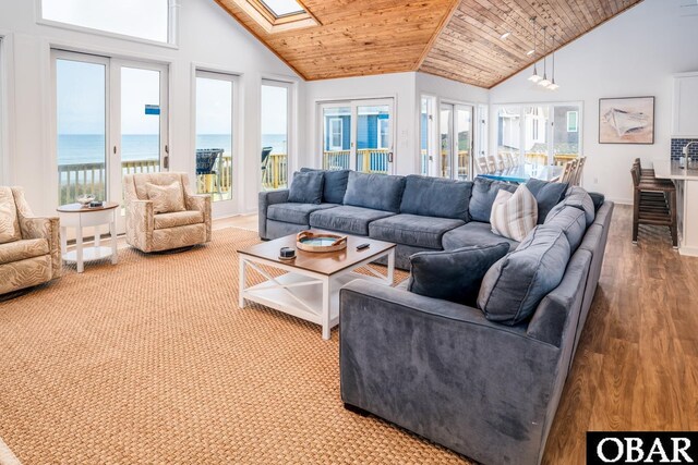 living room with a skylight, wood ceiling, a water view, and plenty of natural light