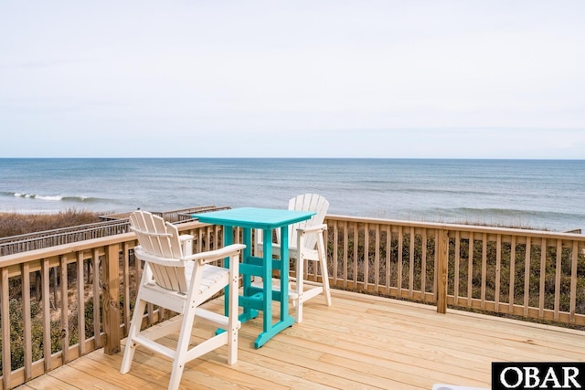 wooden deck with a water view and a view of the beach