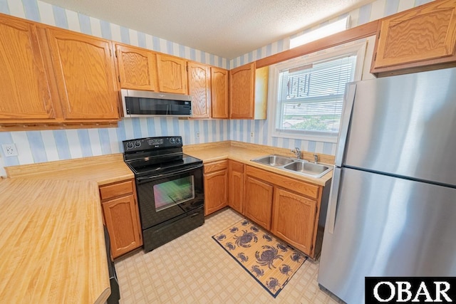 1518 N Virginia Dare Trl Lot # 11, Kill Devil Hills, NC 27948 - kitchen with appliances with stainless steel finishes, a sink, wallpapered walls, light countertops, and light flooring
