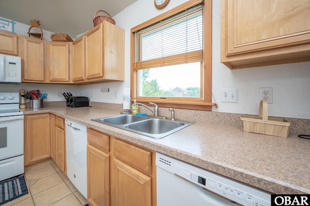 kitchen with light brown cabinetry, light tile patterned flooring, white appliances, light countertops, and a sink
