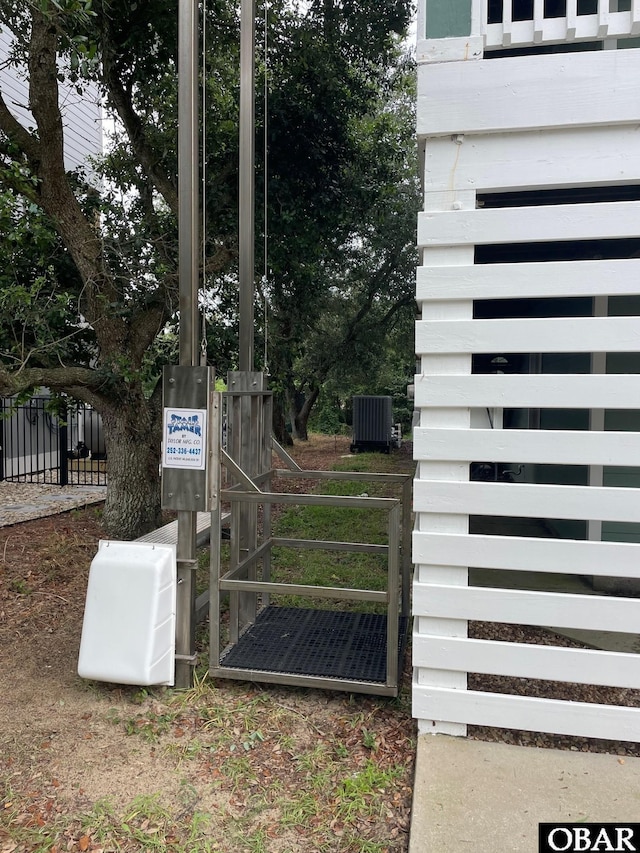 exterior details featuring fence, a gate, and central AC unit