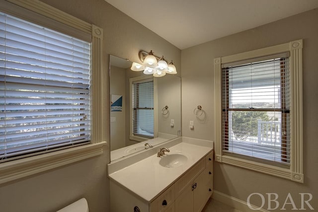 half bath with vanity and baseboards