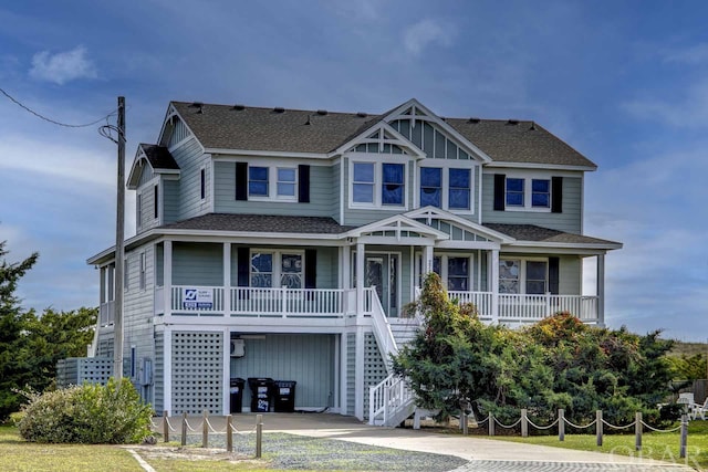 view of front facade featuring a shingled roof, stairs, a porch, and board and batten siding