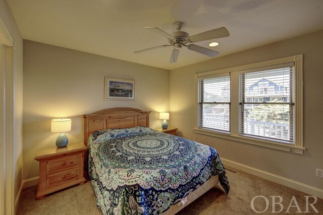 bedroom with light carpet, ceiling fan, and baseboards