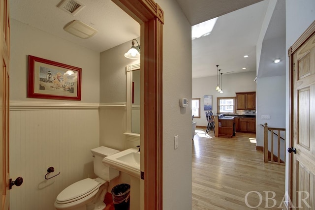 bathroom with visible vents, toilet, and wood finished floors