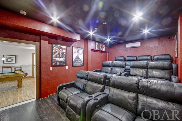 home theater room with a textured wall, an AC wall unit, billiards, and wood finished floors