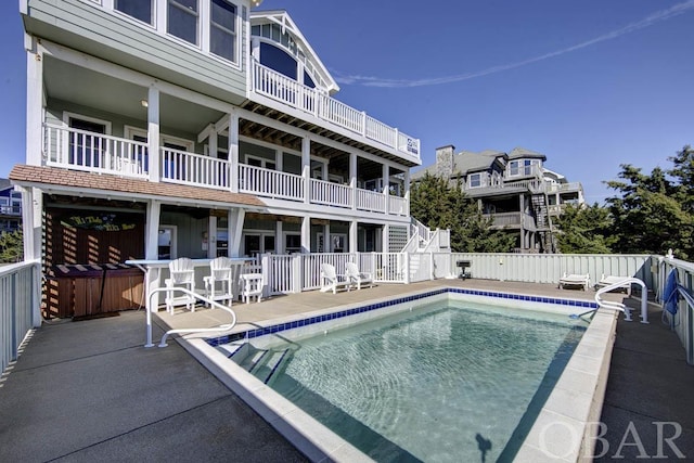 community pool with a patio area and fence