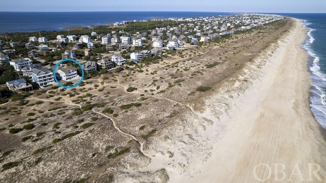 drone / aerial view featuring a beach view, a residential view, and a water view