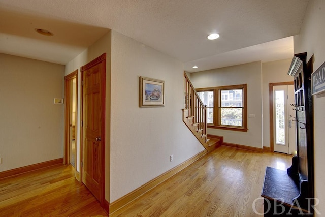 entryway featuring stairs, light wood finished floors, recessed lighting, and baseboards