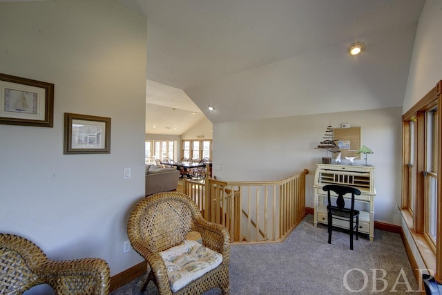 sitting room featuring carpet, baseboards, and vaulted ceiling