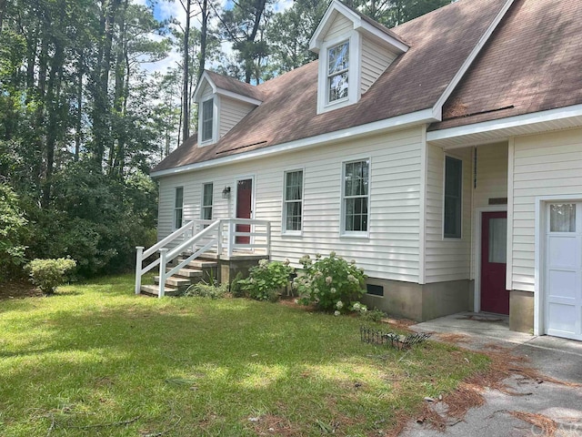 new england style home featuring a garage, a front yard, crawl space, and roof with shingles