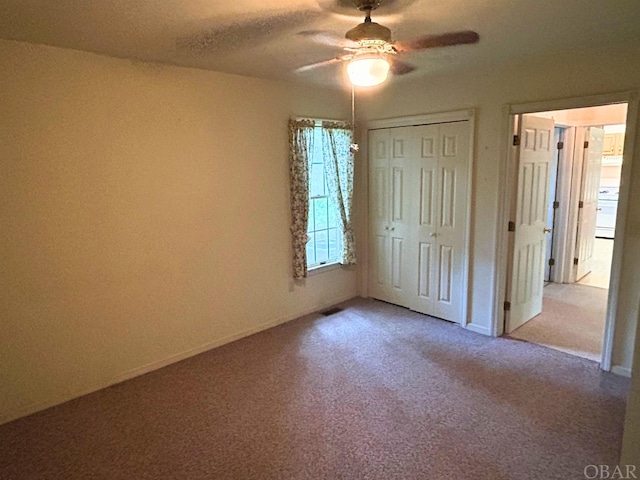 unfurnished bedroom with a closet, carpet flooring, and ceiling fan