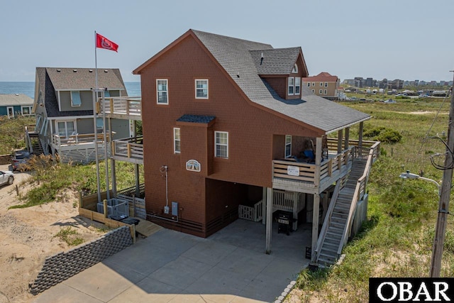 view of front of property with a deck, a carport, concrete driveway, and cooling unit